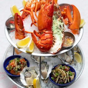 Chilled seafood tower with raw oysters, shrimp cocktail, ahi poke, smoked salmon poke, lomi salmon, whole lobster and king crab legs.